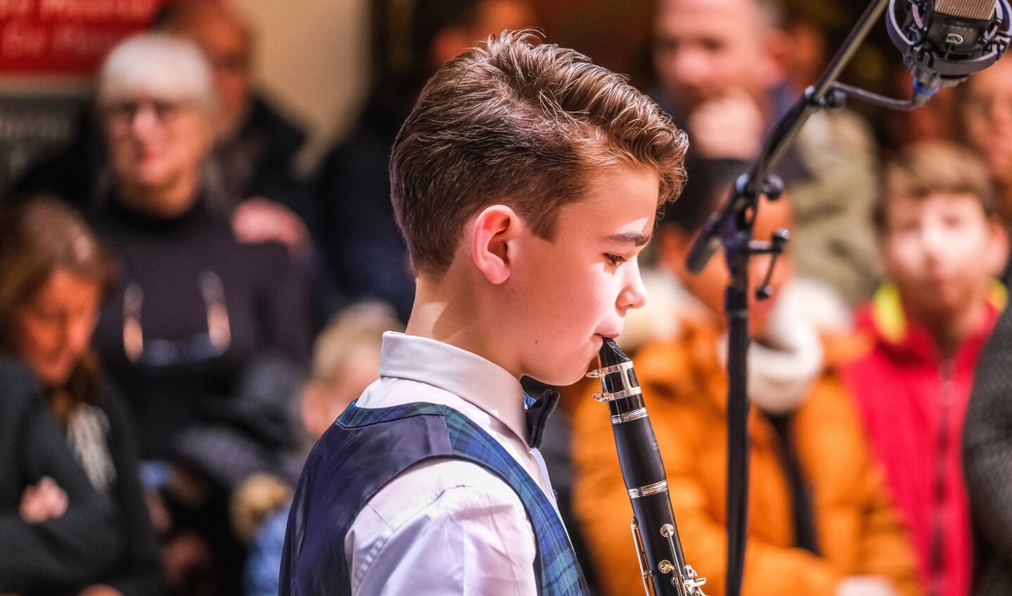 Een jonge klarinettist verzorgt een optreden. 