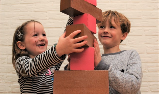 Janne en Bruno werken samen aan de roze toren en bruine trap.