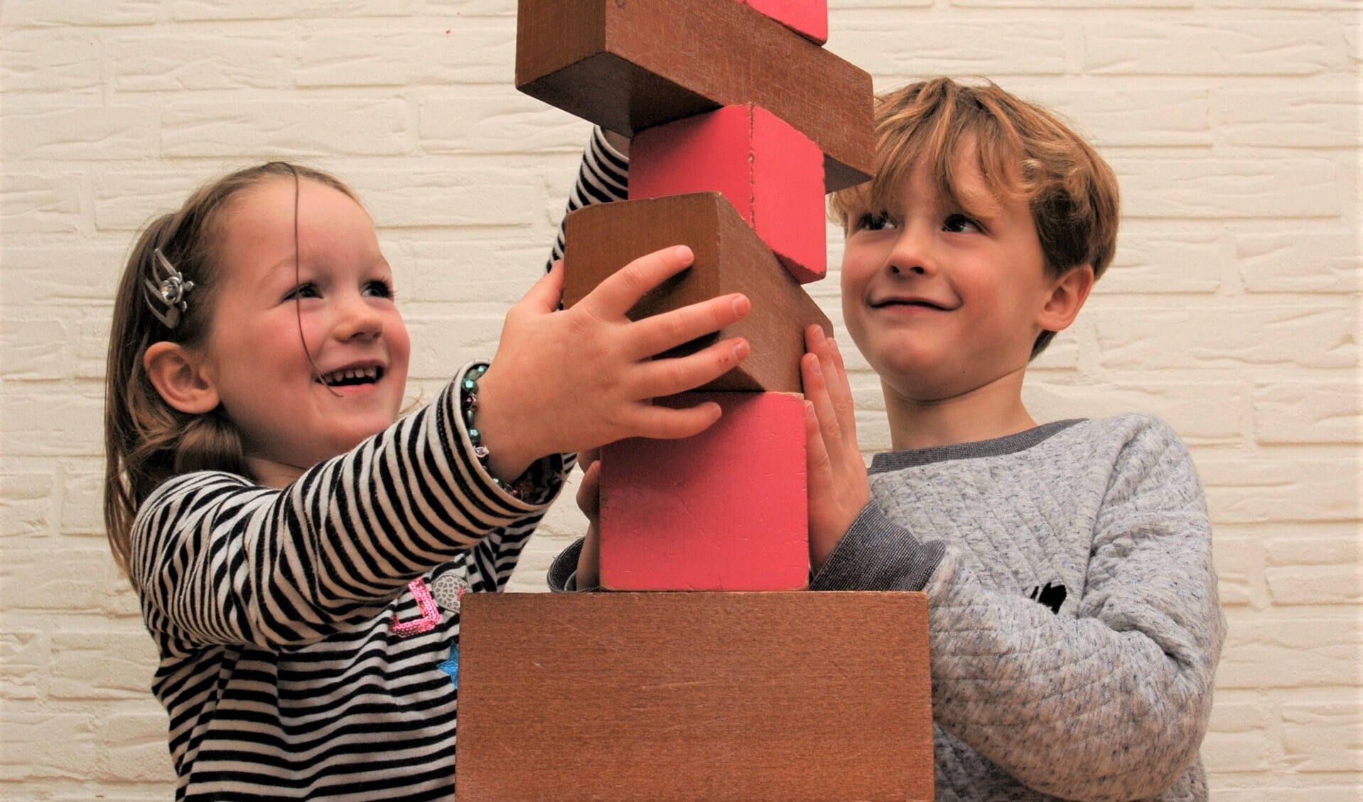 Janne en Bruno werken samen aan de roze toren en bruine trap.