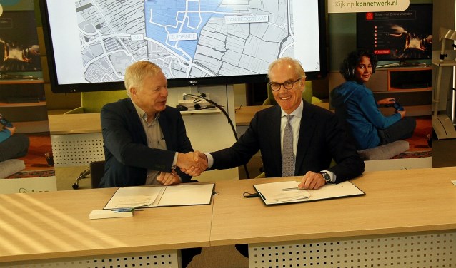 Wethouder Quakernaat en KPN-directeur Offerhaus bekrachtigen de samenwerking met een handdruk.
