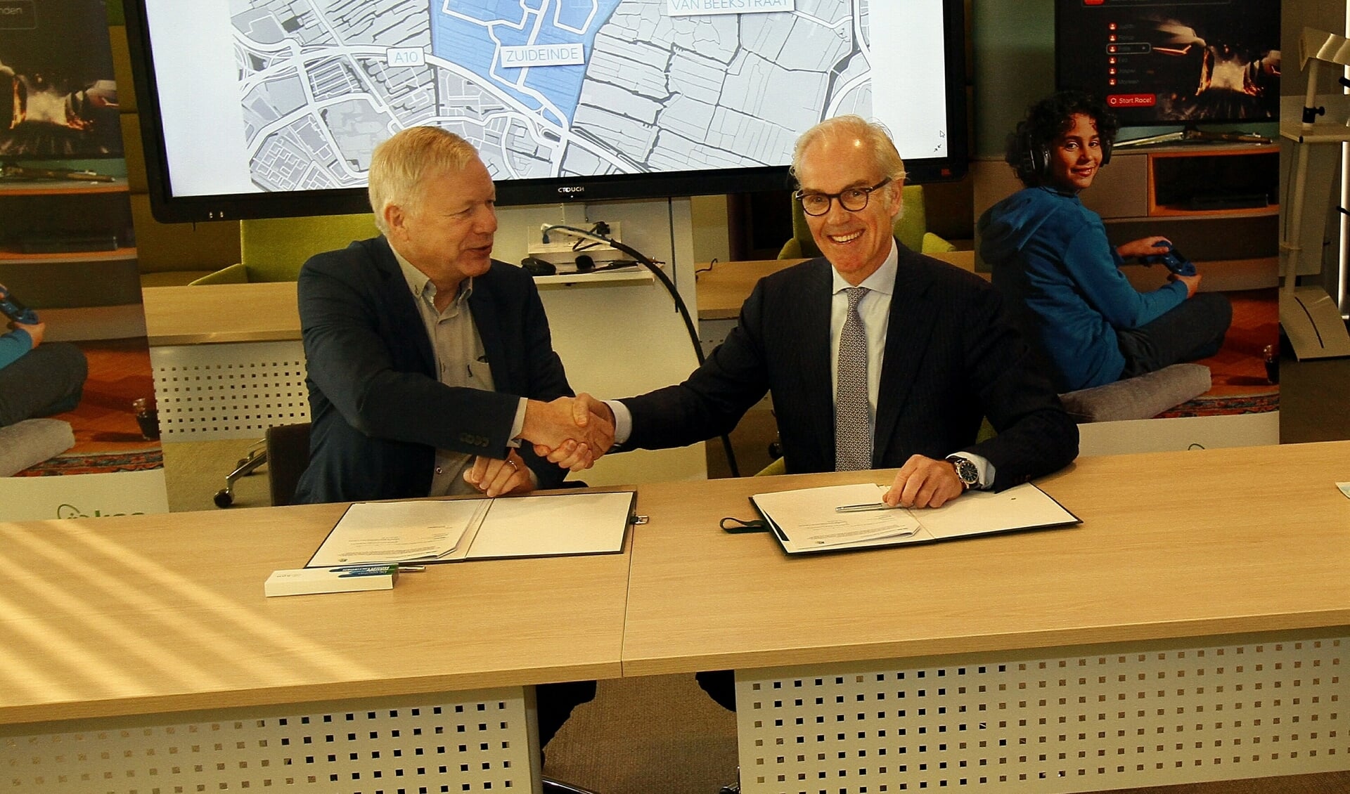 Wethouder Quakernaat en KPN-directeur Offerhaus bekrachtigen de samenwerking met een handdruk. 