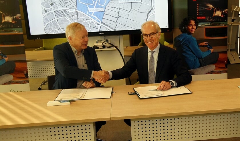 Wethouder Quakernaat en KPN-directeur Offerhaus bekrachtigen de samenwerking met een handdruk.