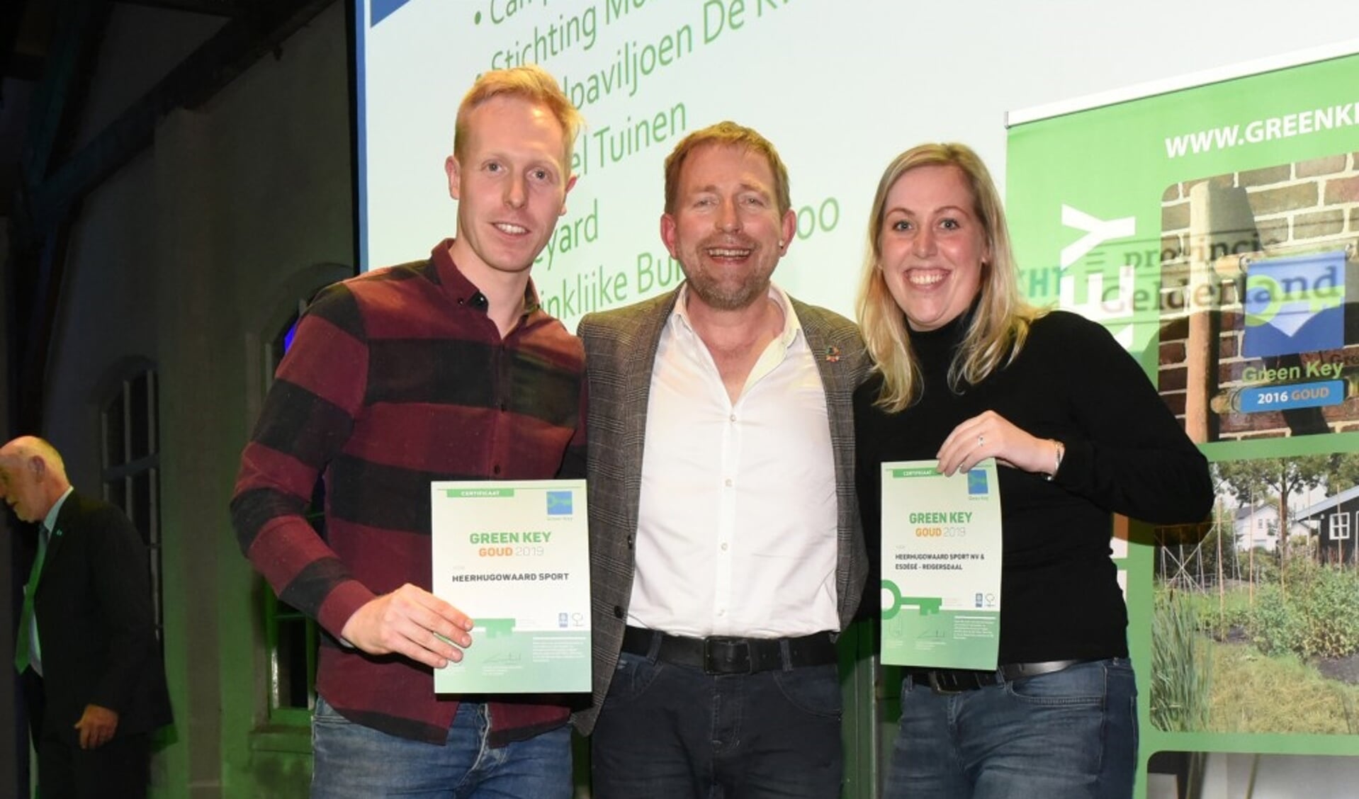 Danny de Boer en Jill Zuurbier van het Green Team Heerhugowaard Sport NV, met tv-presentator Harm Edens in hun midden.