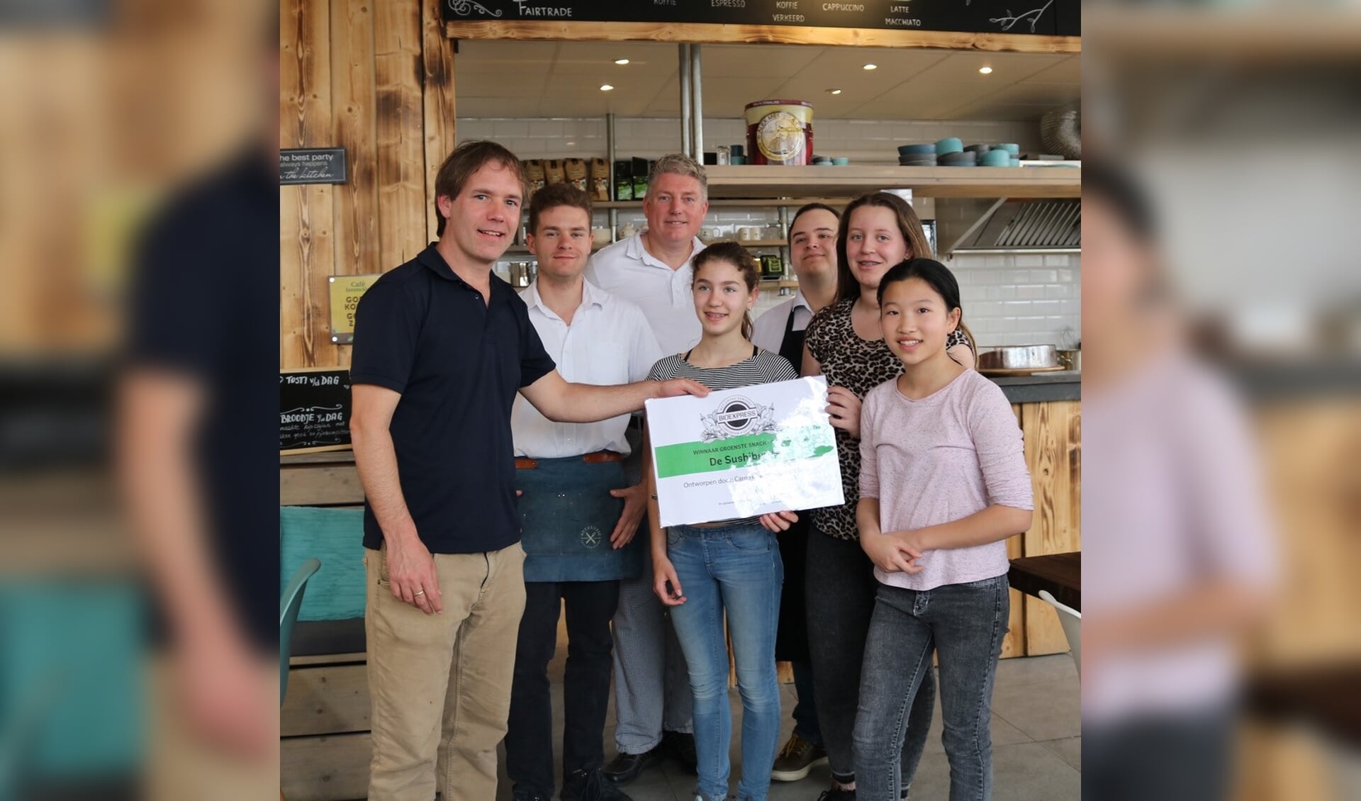 Het personeel van de BioExpress reikt de prijs uit aan Team Sushi-burger. 