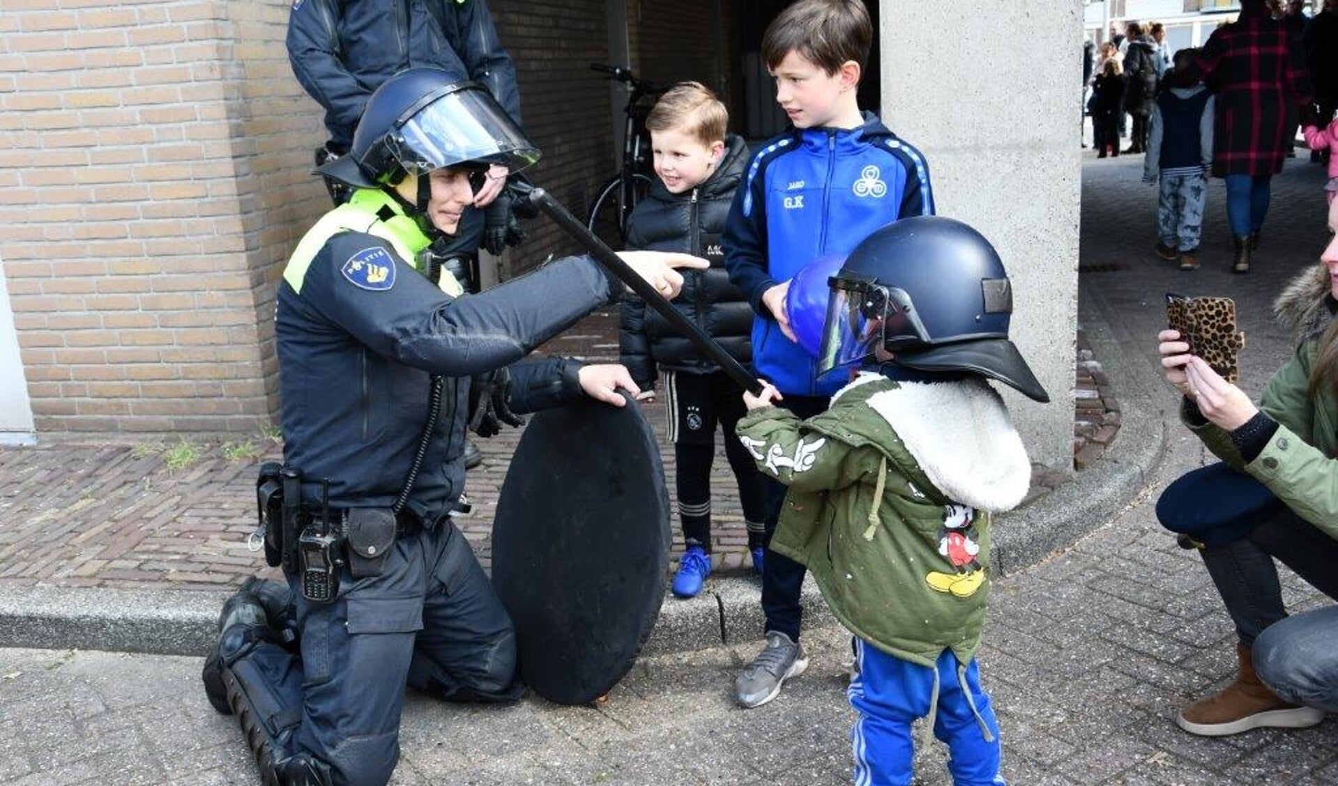 Deze politieman legt de jongste jeugd iets uit.