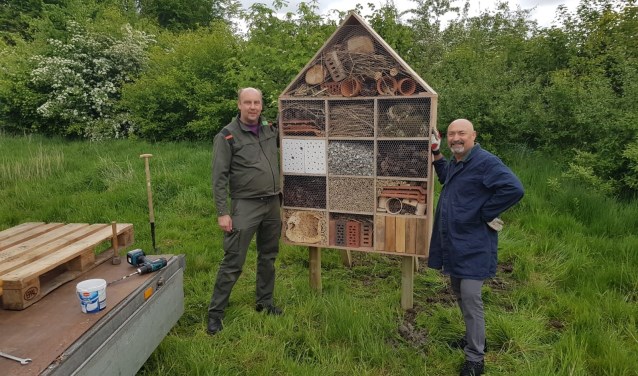 Boswachter Paul Bot (l) en onderwijsassistent Babis Saridakis begeleiden de scholieren bij het maken van de bijenhotels.