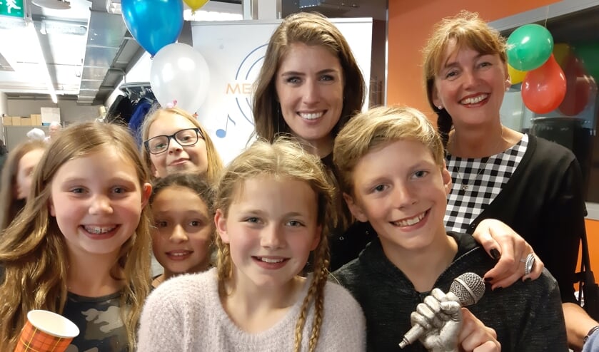 Marieke Elsinga met leerlingen van de Zwanebloem die de zilveren microfoon hebben gewonnen.