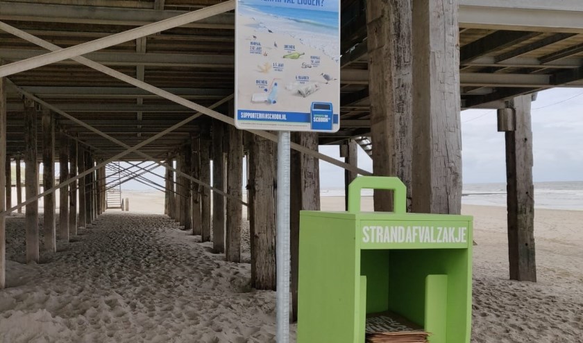 Speciale houders met papieren afvalzakjes neergezet bij de strand etablissementen
