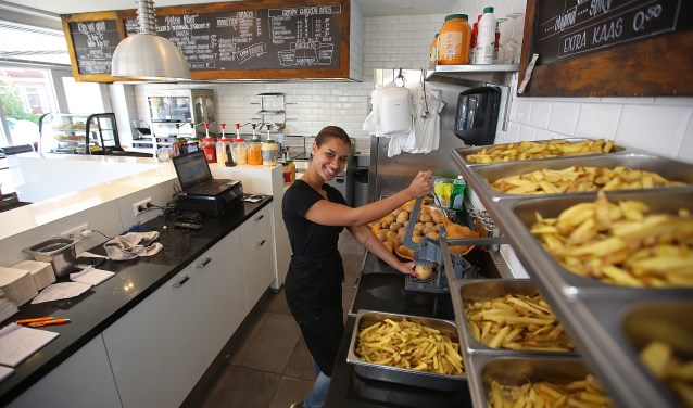 Medewerkster Igone voorziet de klant van heerlijke friet.