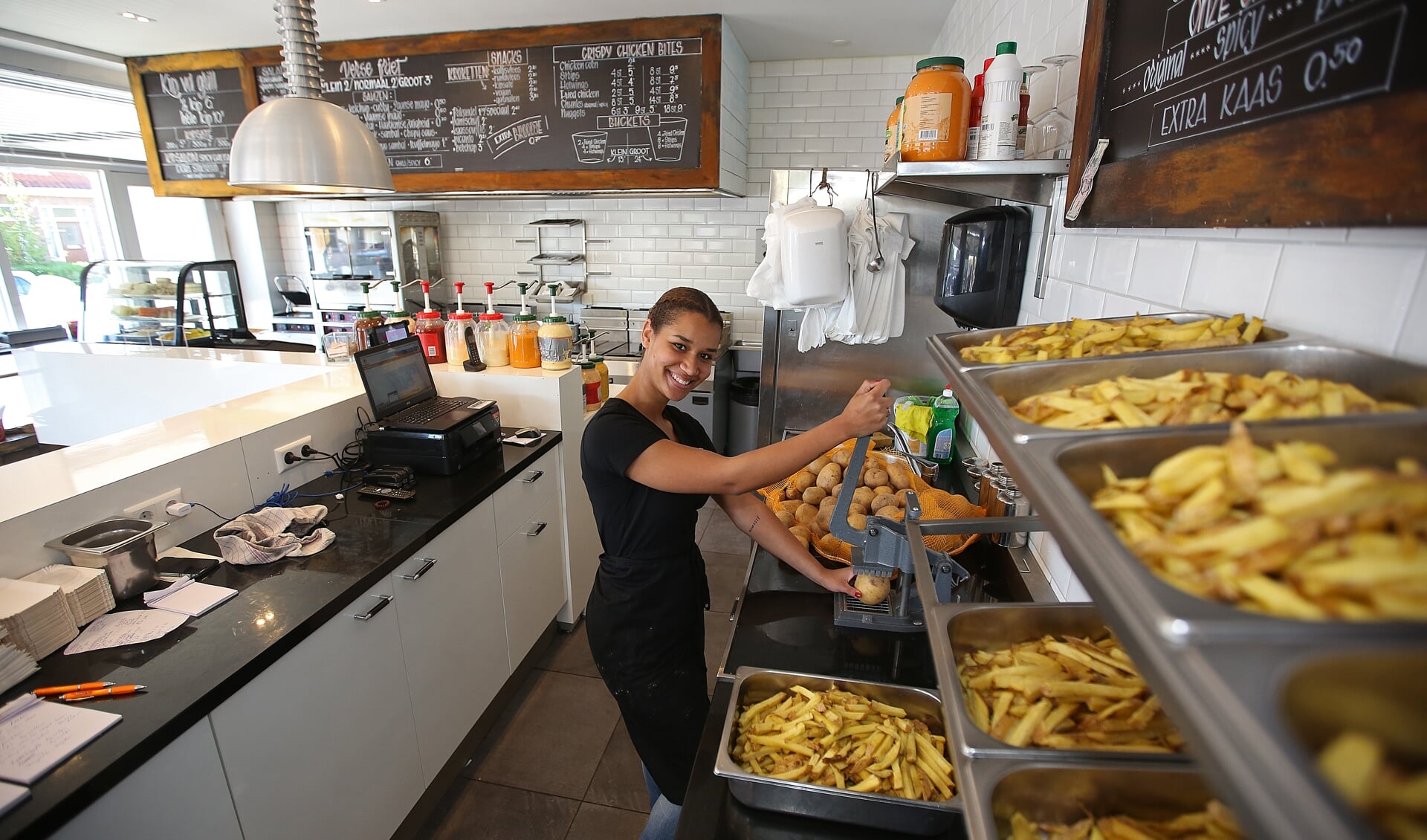 Medewerkster Igone voorziet de klant van heerlijke friet.