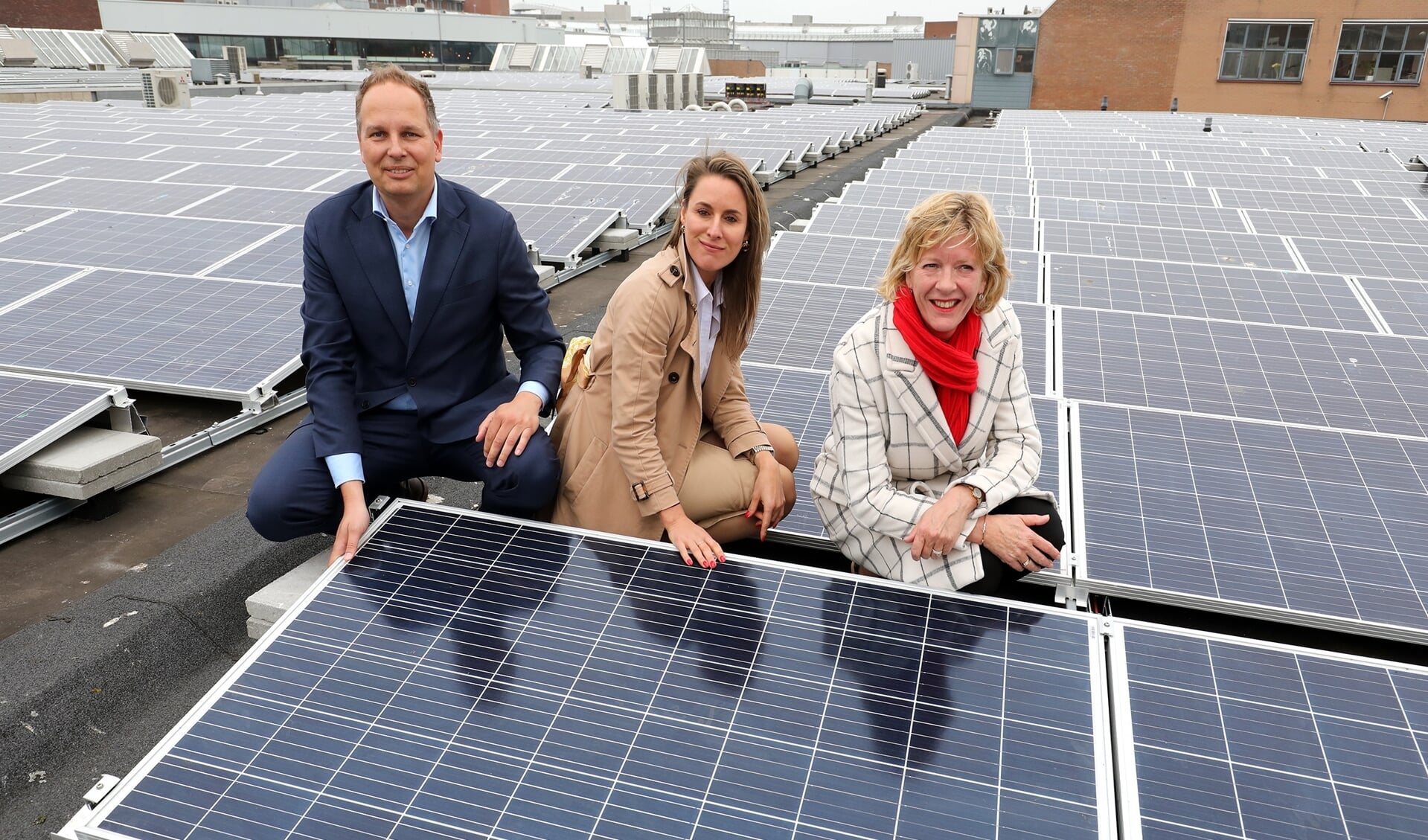 Vlnr. Duco Beltman (Wereldhave), Doris Slegtenhorst (Wereldhave) en wethouder Monique Stam bij de zonnepanelen op het dak van Middenwaard.
