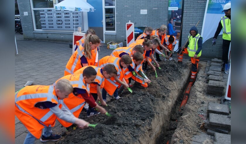Leerlingen van De Hasselbraam mochten het zand weer terug de geul in scheppen.