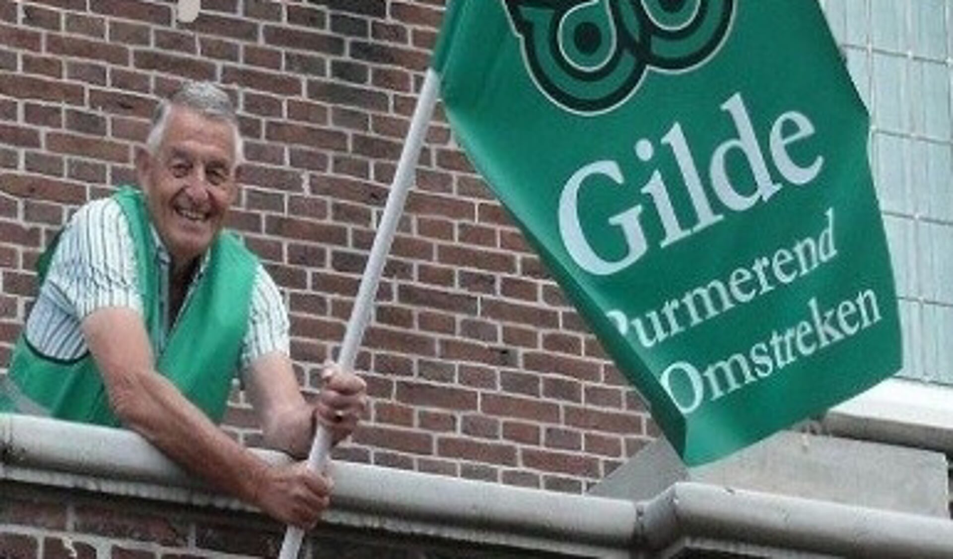 Voorzitter Dick Blokker van Gilde Purmerend en Omstreken hijst de vlag op het oude stadhuis. 