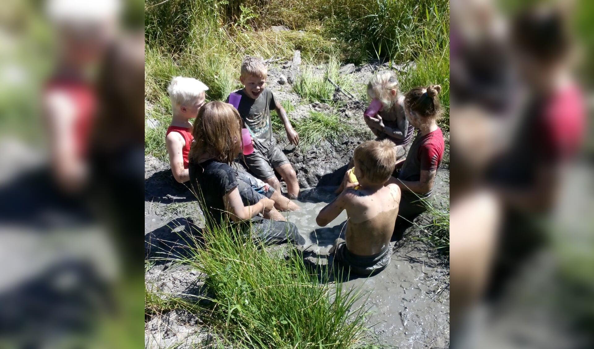 Kinderen ontdekken hoe je met modder kunt spelen. De kleren blijven niet schoon!