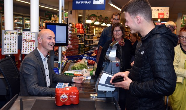 Wethouder Robert Tesselaar controleert een identiteitsbewijs van een jongere die bier wil kopen.