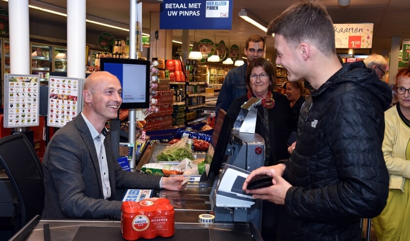 Wethouder Robert Tesselaar controleert een identiteitsbewijs van een jongere die bier wil kopen.