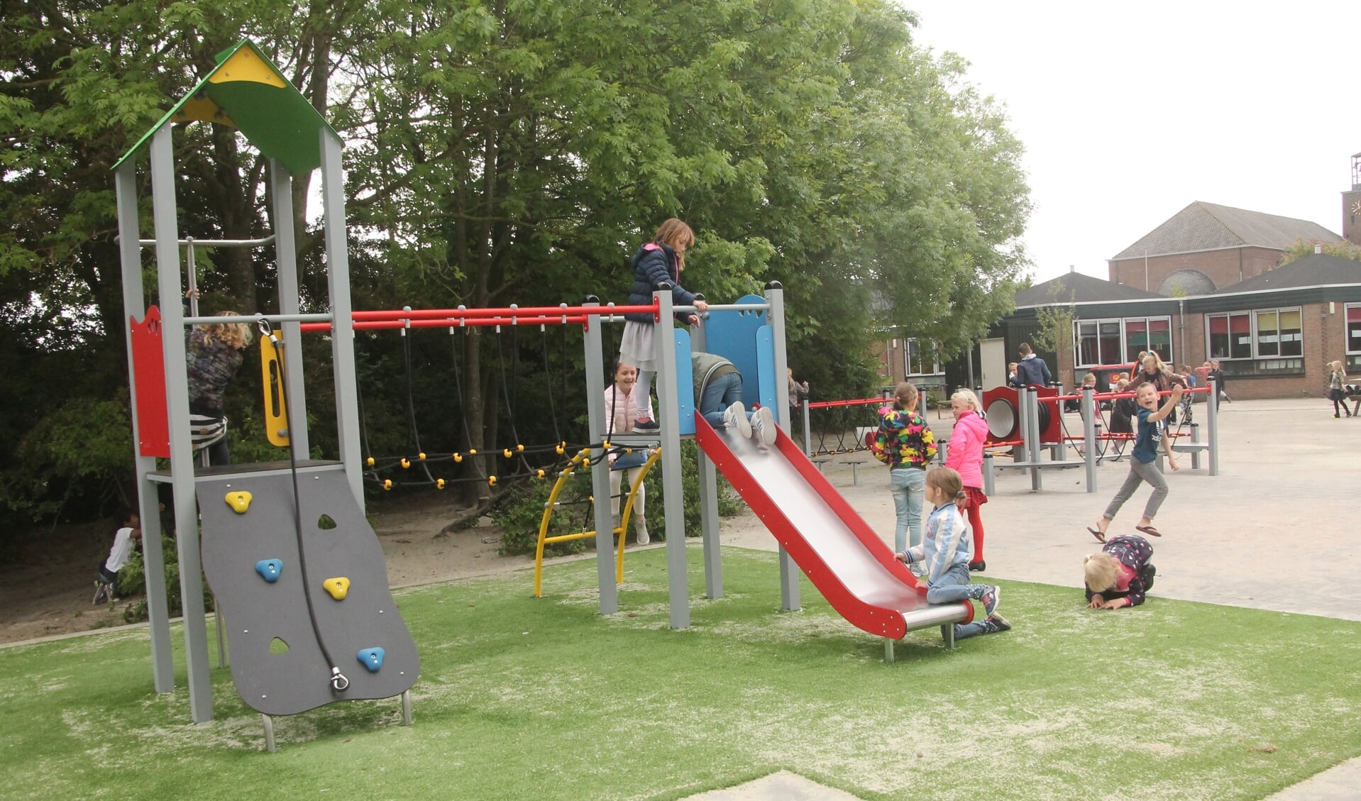 Spelende kinderen op de nieuwe speeltoestellen van Jozefschool in Venhuizen.