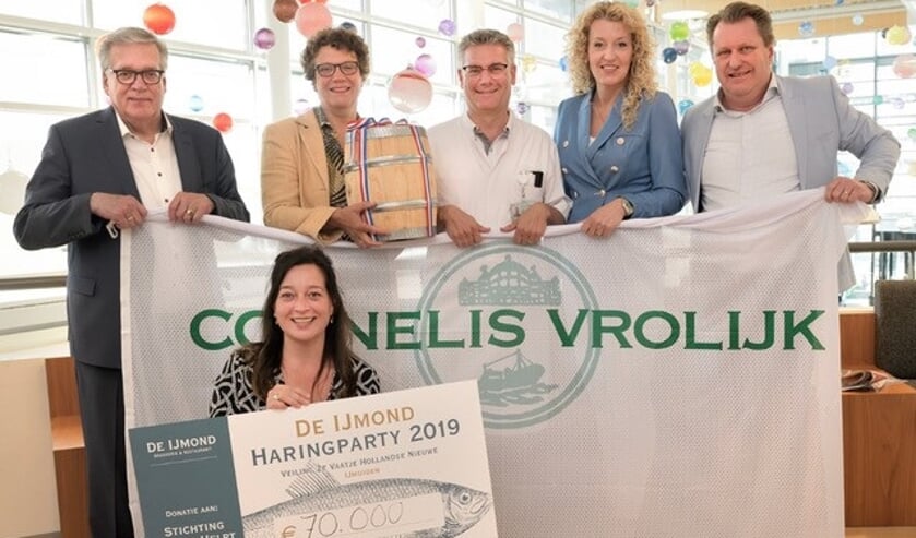 Het tweede vaatje Hollandse Nieuwe wordt door Brigitte Paulissen (tweede van links) overhandigd aan Dr. Blank van het Antoni van Leeuwenhoek ziekenhuis. Carola zelf en haar man Mark (rechts) zijn daar uiteraard ook bij aanwezig.