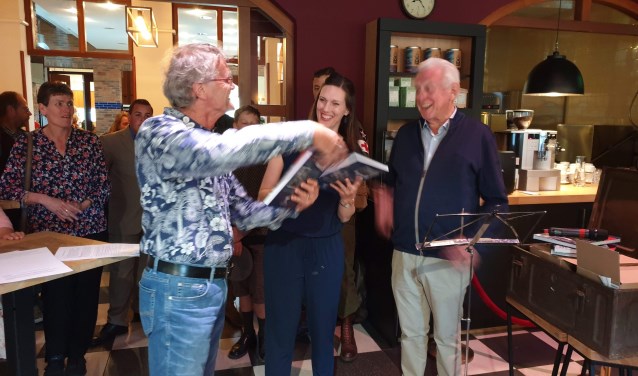 Jan Windt en Marloes van Ede ontvangen het eerste boek uit handen van voorzitter Wim Kersten
