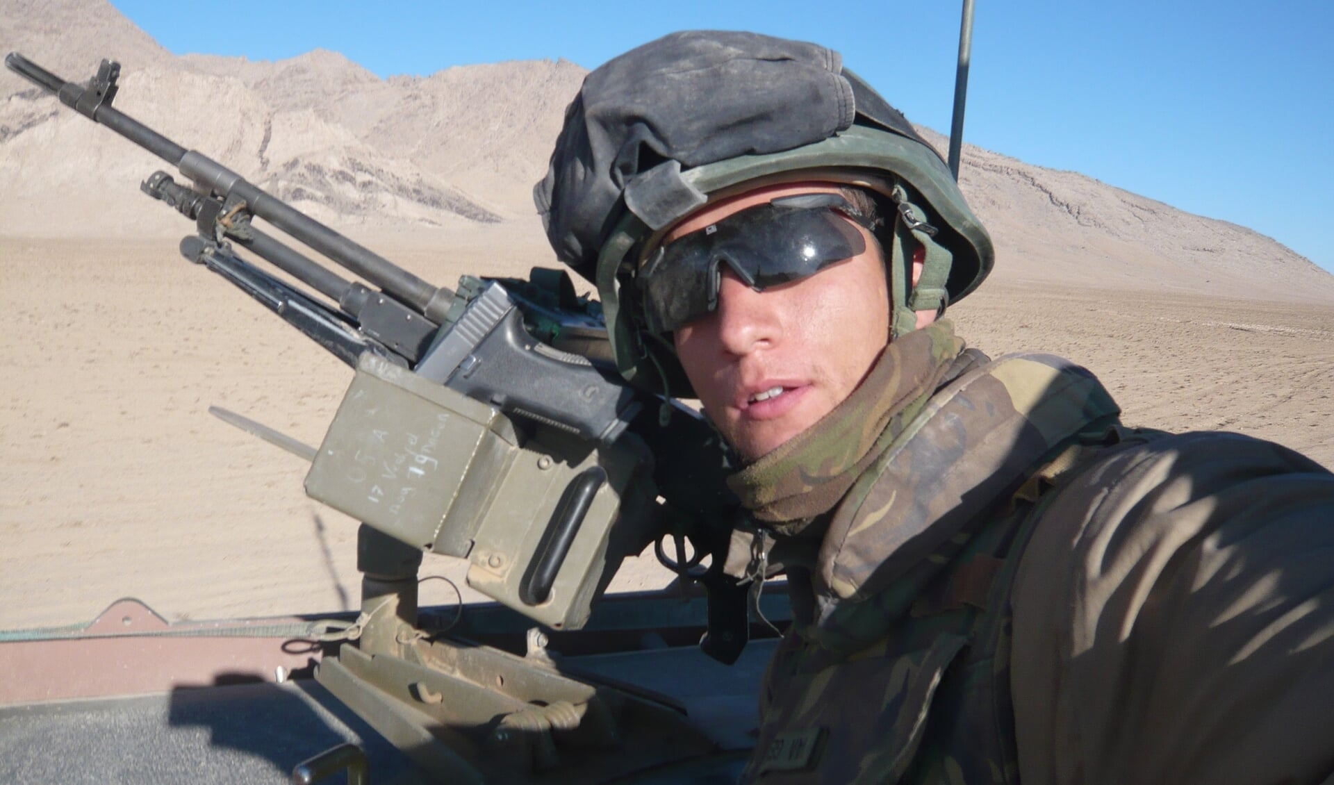 Rijdende patrouille door de woestijn op de Bushmaster als MAG-schutter.