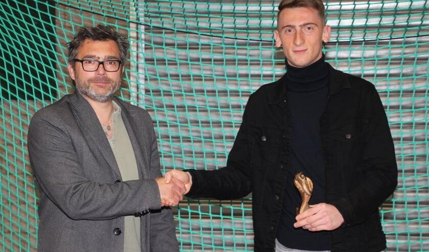 Voorzitter Ronald Eeken (l) van stichting Recreatiezaalvoetbal Heerhugowaard reikt de Joosten Staalbouw topscorerstrofee uit aan Sercan Yilmaz.