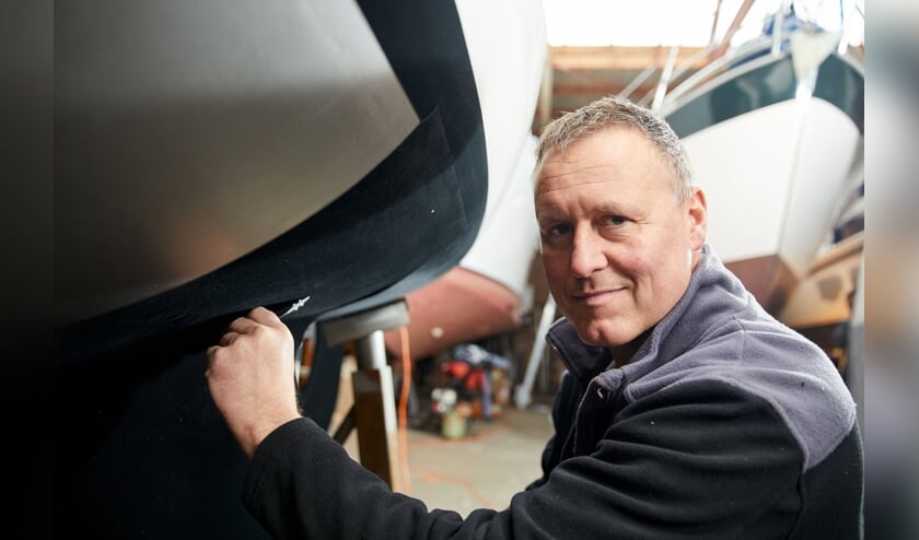 Rik Breur plakt het door hem uitgevonden zelfklevend antifouling ‘tapijt’ op een boot.