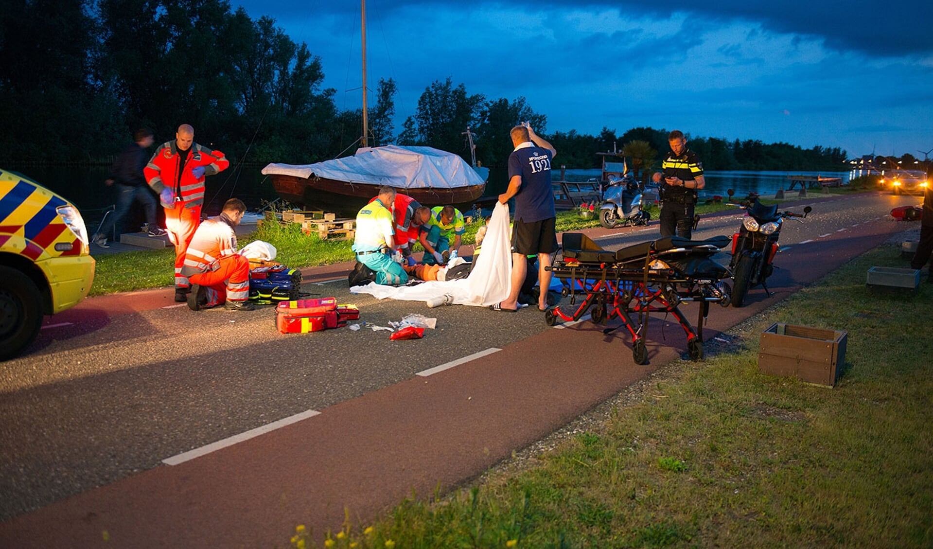 Ter plaatse heeft de gewonde motorrijder alle zorg nodig van het ambulancepersoneel. 
