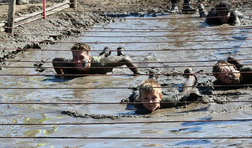 De strak gespannen touwen boven het modderbad dwingen de deelnemers diep te gaan.