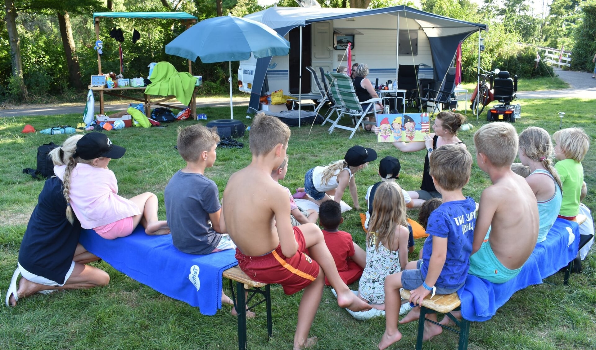 Kinderen worden voorgelezen tijdens het kampeerweekend in het Agathepark. 