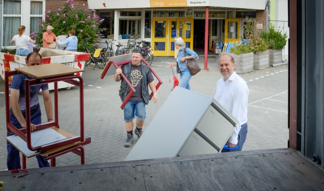 Burgemeester Bert Blase (r) helpt bij het inladen van meubelstukken voor Stichting Miss IQ.