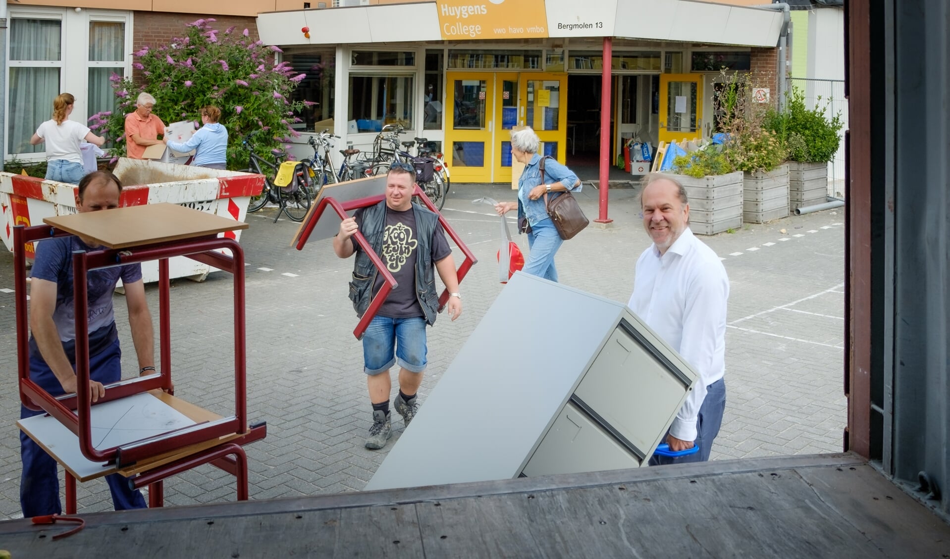 Burgemeester Bert Blase (r) helpt bij het inladen van meubelstukken voor Stichting Miss IQ.