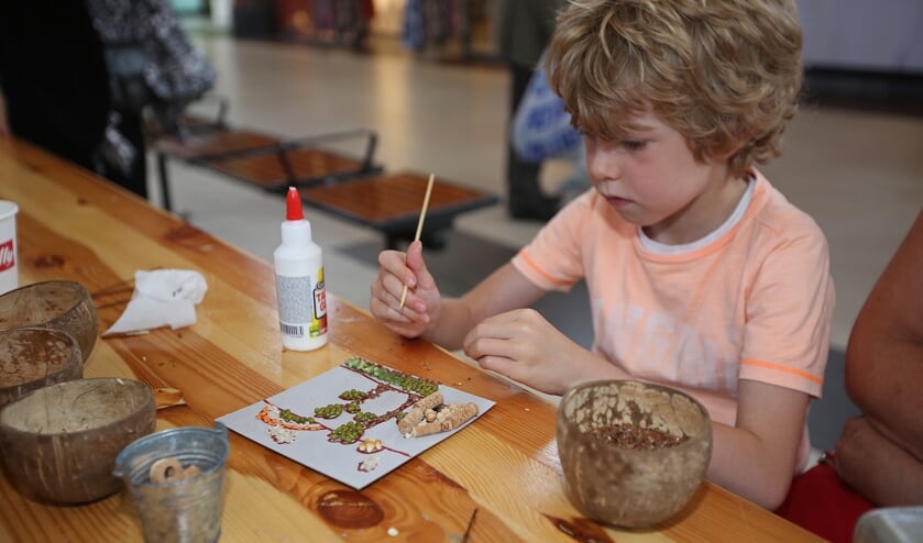 Kian is geconcentreerd bezig met zijn creatieve zomermozaïek.