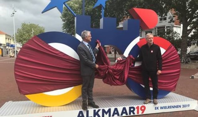 Wethouder Pieter Dijkman en Vincent Thijssen onthullen deze supergrote fiets op station Alkmaar.