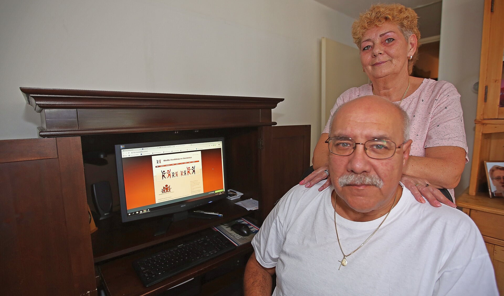Theo Tielman en zijn vrouw achter de computer die de website van Minima Hoofddorp en Omstreken toont. 