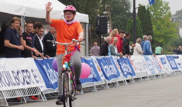 Met een grote glimlach en vol trots passeren deelnemers aan de G-race het enthousiaste publiek.