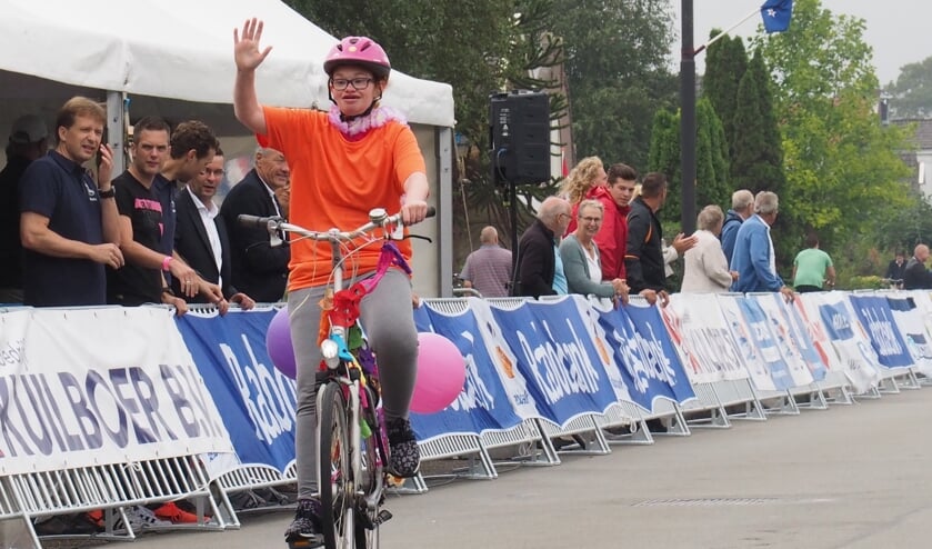 Met een grote glimlach en vol trots passeren deelnemers aan de G-race het enthousiaste publiek.