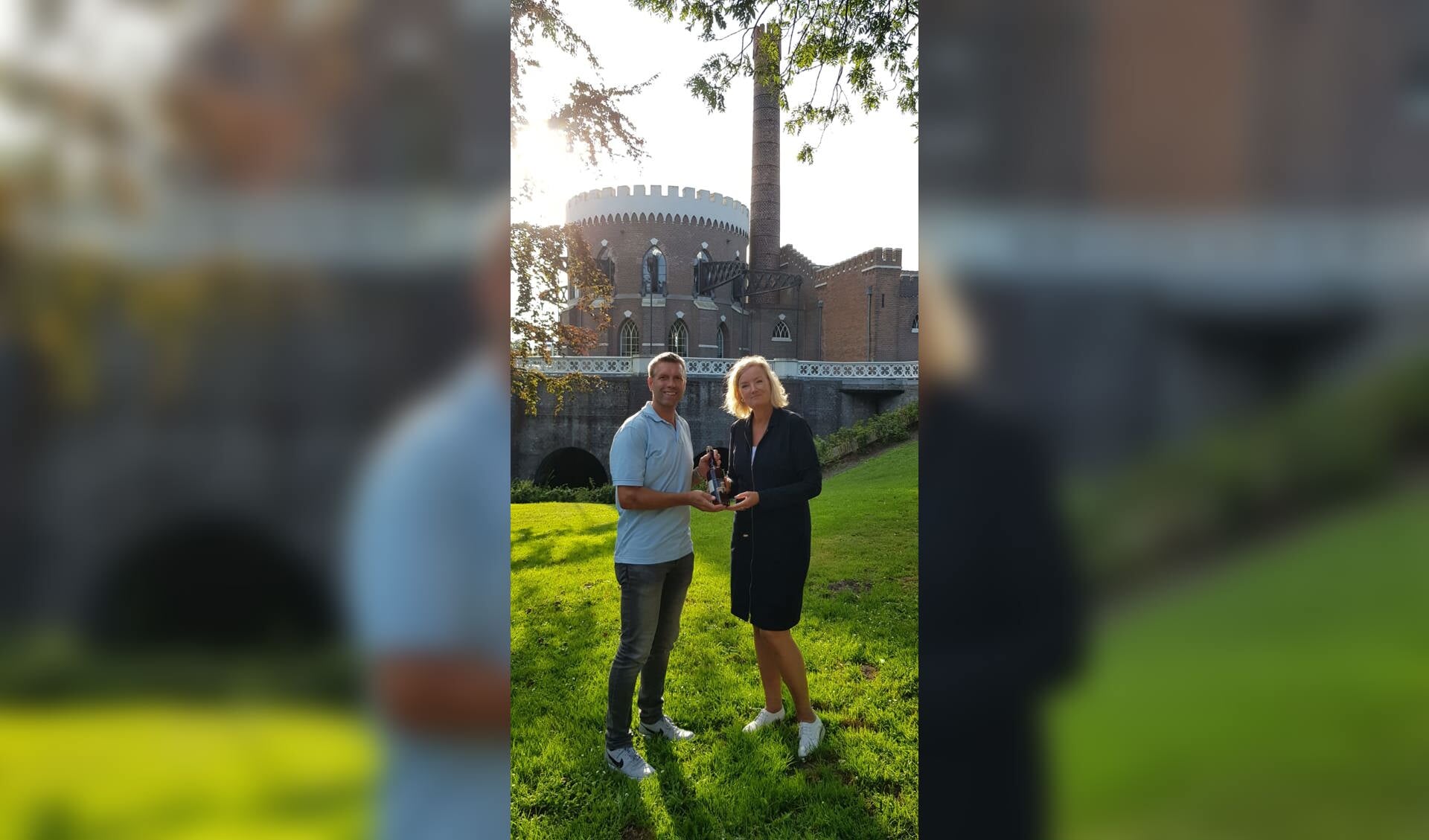 Directeur Haarlemmermeermuseum De Cruquius Elise van Melis neemt het eerste Cuvée de Cruquius in ontvangst van Edwin van der Zwet van Brouwerij Poort.