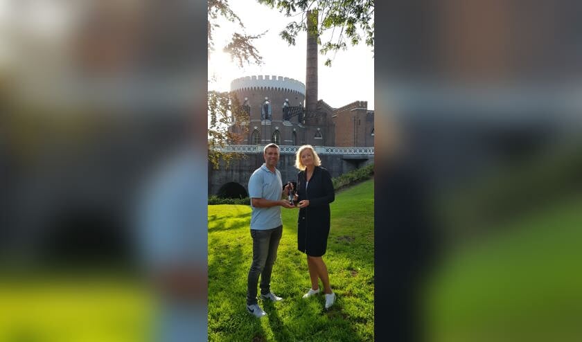 Directeur Haarlemmermeermuseum De Cruquius Elise van Melis neemt het eerste Cuvée de Cruquius in ontvangst van Edwin van der Zwet van Brouwerij Poort.