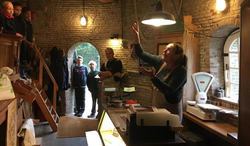 Vrijwillig molenaar Tessa Krop met leerlingen groep 7 op bezoek in de molen, hier op 'de maalvloer
