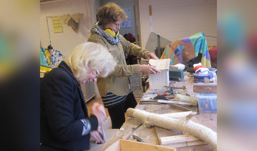 Ellie en Roos bezig met houtbewerken.