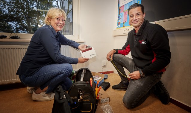 Samen met een monteur van Trined activeert directeur Mariska Buizer (l) van OBS Prinses Beatrix de eerste glasvezelaansluiting in Kwadijk.