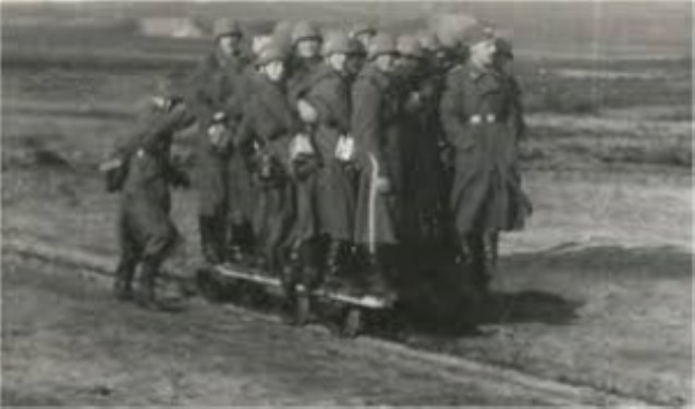 Duitse soldaten spelen met een kiplorrie, rijden mee met een platte lorrie en zijn aan het werk met stenen en een kiplorrie.