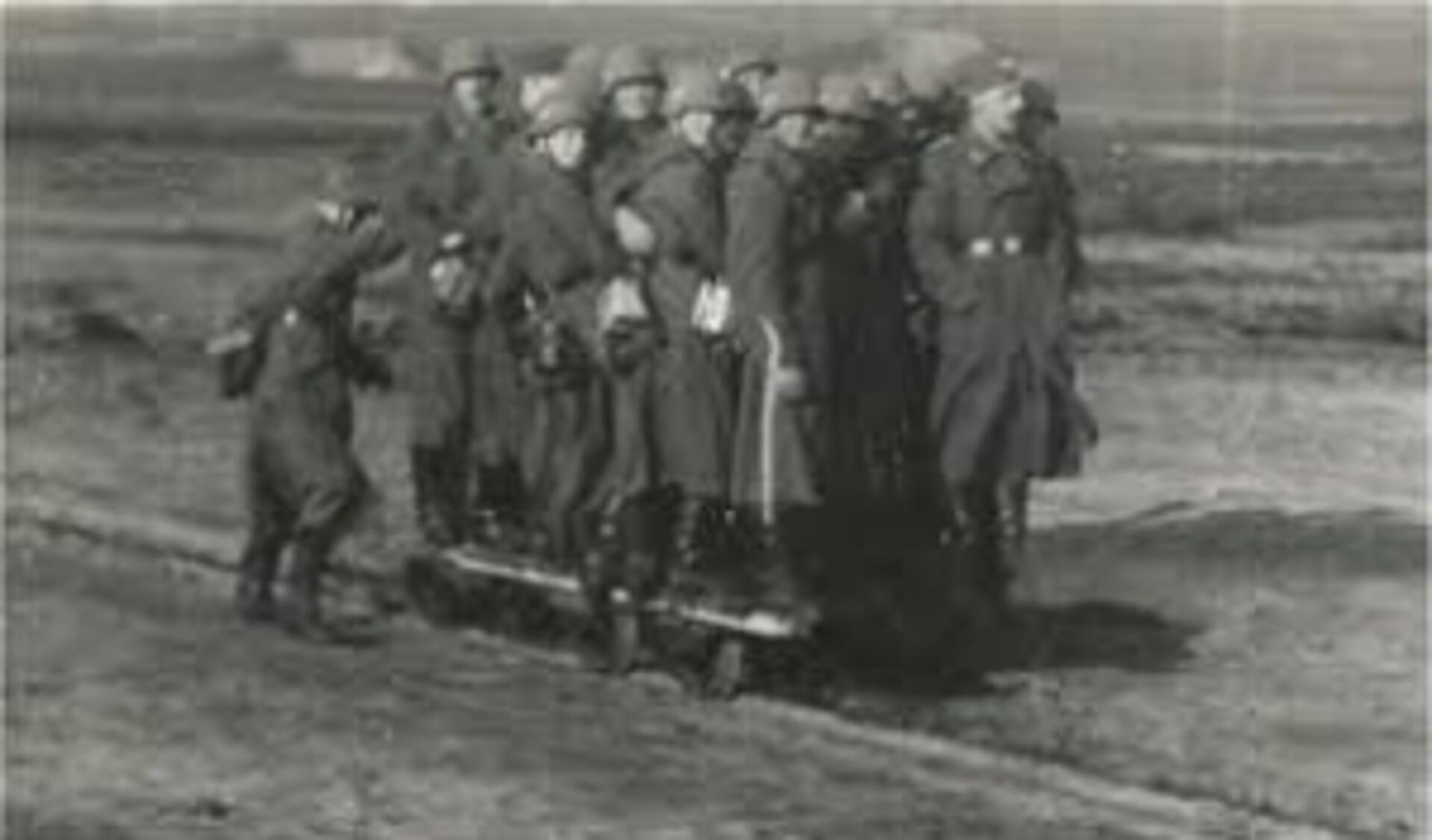 Duitse soldaten spelen met een kiplorrie, rijden mee met een platte lorrie en zijn aan het werk met stenen en een kiplorrie.