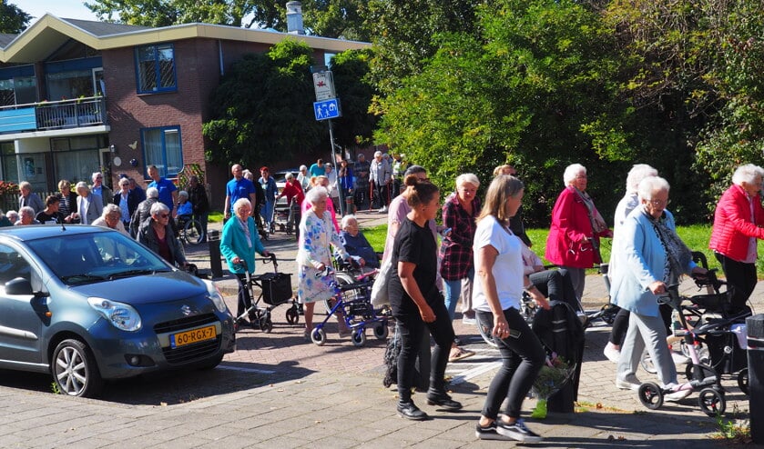 Een lange rij van ongeveer 120 cliënten en begeleiders trekken door de Rosmolenbuurt.
