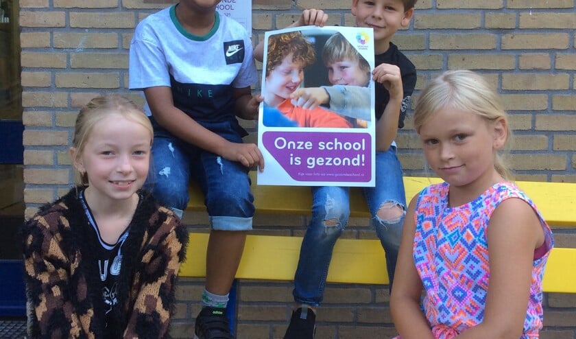 Leerlingen houden het nieuwe vignet omhoog.