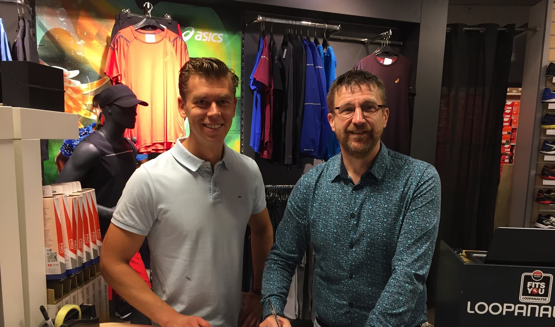 Roy van der Geest (Sport 2000) en Marco van Leersum (VHZ) tekenen de contracten in de Sport 2000 winkel in De Symfonie. 