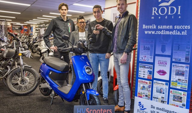 Christian van Goethem van Rodi Media overhandigt de sleutels aan de scooter-winnaar Milan Gennissen.
