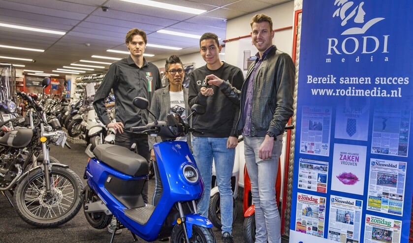 Christian van Goethem van Rodi Media overhandigt de sleutels aan de scooter-winnaar Milan Gennissen.