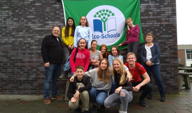 Een deel van eco-team The Greenies poseert trots voor de Groen Vlag met hun begeleidende docenten Jacob Jeltes en Marieke Brehm)