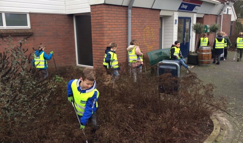 Buiten op het plein en rondom de school vonden de kinderen veel afval in de struiken.